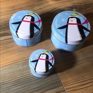 Penguin nesting small metal tins containers